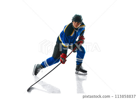 Focused professional hockey player with stick showing of puck control against white studio background. 113858837