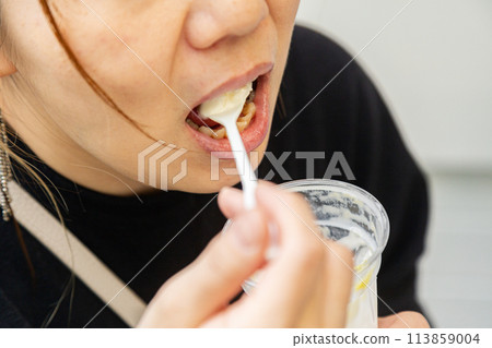 Hands of a woman eating a parfait 113859004