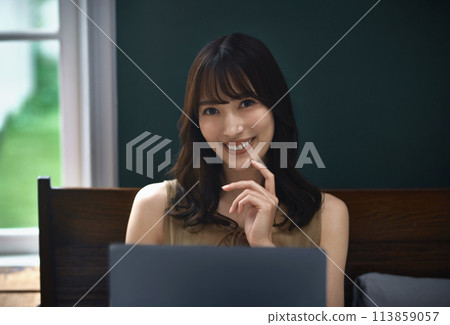 Young woman using a laptop in her bedroom 113859057