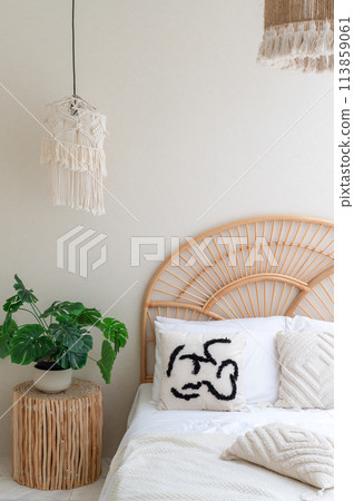 White pillows on wooden weave bed in minimal bedroom interior with green plants. Real photo 113859061