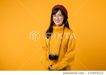 A memory maker and photographer, this young Asian woman, dressed in a yellow sweater and red beret, captures moments artistically with her camera. A memory maker and photographer, this young Asian woman, dressed in a yellow sweater and red beret, captures moments artistically with her camera. 113859122
