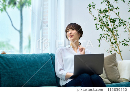 在客廳裡操作個人電腦的女人 113859330