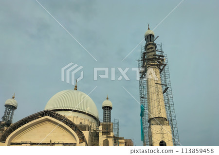 The process of building a new large mosque with several minarets. Exterior decoration works at height with the help of industrial scaffolding The process of building a new large mosque with several minarets. Exterior decoration works at height with the help of industrial scaffolding 113859458