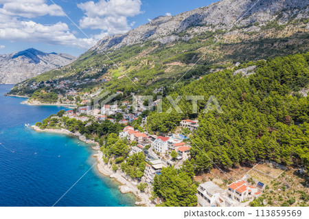 Aerial view of Punta Rata beach with boats and azure sea in Brela, Croatia, Dalmatia, Croatian azure coast Aerial view of Punta Rata beach with boats and azure sea in Brela, Croatia, Dalmatia, Croatian azure coast 113859569