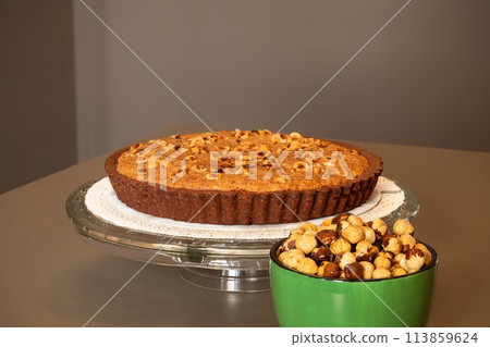 Chocolate tart with hazelnut cream and bowl of nuts 113859624