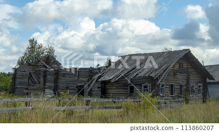old abandoned and overgrown wooden village house 113860207