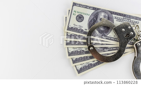 iron handcuffs and and hundred dollar bills on a white background iron handcuffs and and hundred dollar bills on a white background 113860228