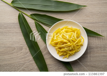 Close up sliced yellow Pickled bamboo shoots on white plate.Top view 113861397