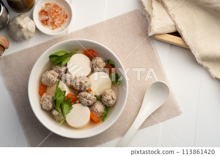 Clear soup with soy bean curd ,Minced Pork glass noodles and Vegetables in white bowl.Top view 113861420