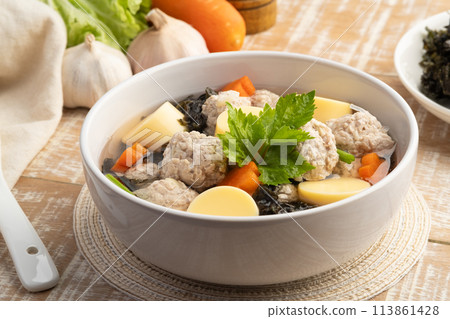Thai style Clear seaweed soup with glass noodle, Minced Pork,Vegetables and egg tofu in white bowl.(Gaeng Jued ) 113861428