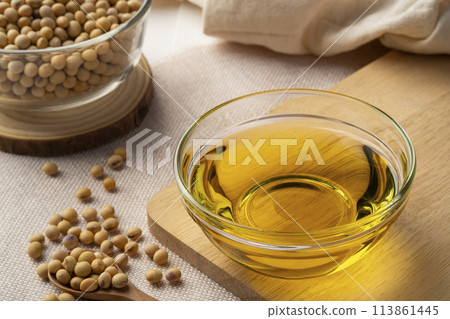 Soybean oil,is a vegetable oil extracted from the seeds of the soybean,in glass bowl on wooden table Soybean oil,is a vegetable oil extracted from the seeds of the soybean,in glass bowl on wooden table 113861445
