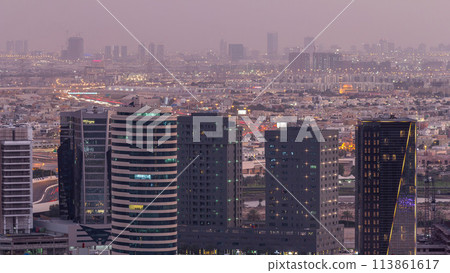 Dubai's business bay towers at evening aerial day to night timelapse. Dubai's business bay towers at evening aerial day to night timelapse. 113861617