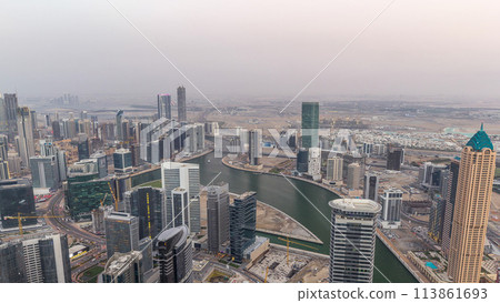 Panoramic aerial view of business bay towers in Dubai day to night timelapse. Panoramic aerial view of business bay towers in Dubai day to night timelapse. 113861693