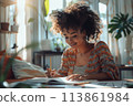 happy dark-skinned woman drawing with pencils in colouring book 113861984