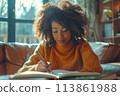 happy dark-skinned woman drawing with pencils in colouring book 113861988