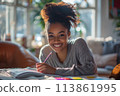 happy dark-skinned woman drawing with pencils in colouring book 113861995