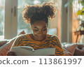 happy dark-skinned woman drawing with pencils in colouring book 113861997