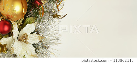 Christmas balls with tinsel and artificial decorative poinsettia on ight background. 113862113