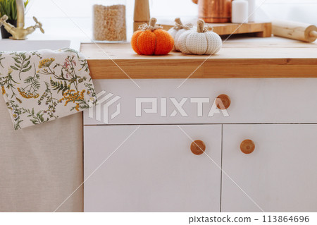 A kitchen counter with a white cabinet and a towel with a floral design 113864696