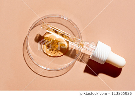 Dropper pipette and petri dish with oil gel  drops 113865926