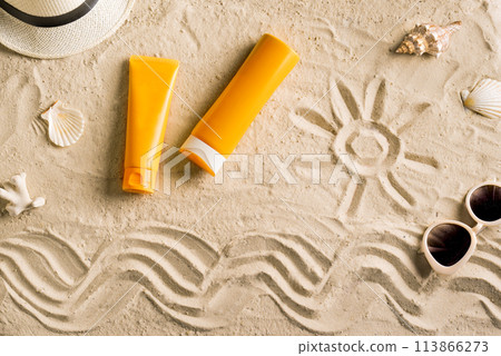 Sunblock, sunglasses and hat on summer sandy beach 113866273