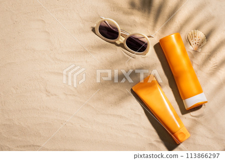 Sunblock lotion bottles on sandy beach Sunblock lotion bottles on sandy beach 113866297