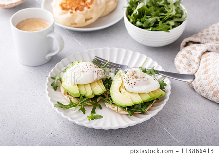 English muffins with arugula, avocado and poached eggs, healthy eggs benedict English muffins with arugula, avocado and poached eggs, healthy eggs benedict 113866413