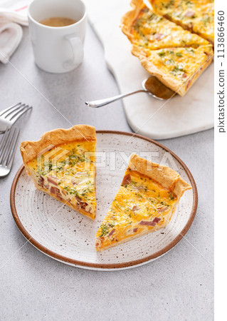 Homemade quiche with ham and cheese cut on the table 113866460