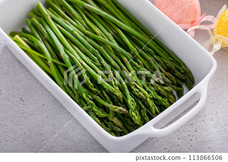 Blanched young asparagus in a baking pan 113866506