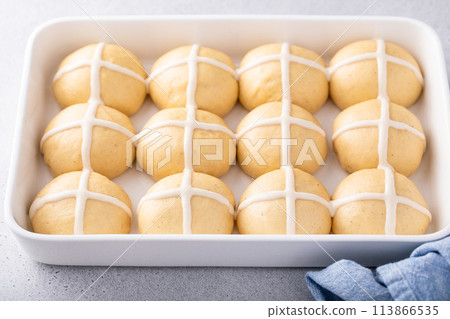 Hot cross buns ready to be baked in a pan with cross pattern 113866535