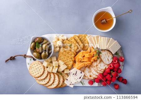 Small cheese and cracker board with fresh berries and olives Small cheese and cracker board with fresh berries and olives 113866594