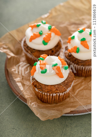Carrot cake cupcakes with cream cheese frosting decorated with little carrots Carrot cake cupcakes with cream cheese frosting decorated with little carrots 113866619