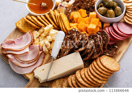 Cheese and snacks board with charcuterie, crackers and variety of snacks Cheese and snacks board with charcuterie, crackers and variety of snacks 113866646