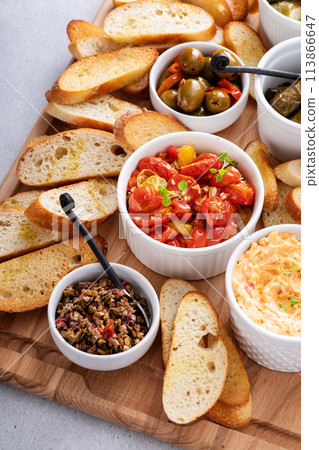 Dips and snacks board with toasted baguette, pimento cheese, olives and tomatoes Dips and snacks board with toasted baguette, pimento cheese, olives and tomatoes 113866647