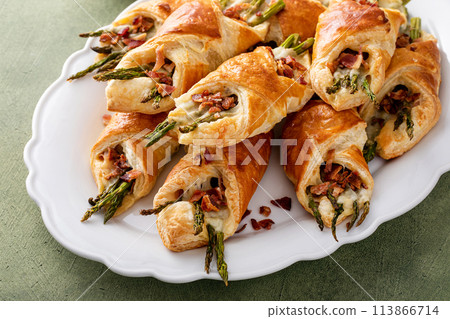 Asparagus appetizers wrapped in puff pastry with melted cheese Asparagus appetizers wrapped in puff pastry with melted cheese 113866714