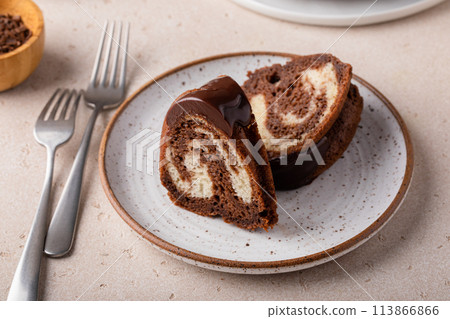 Marbled bundt cake sliced on a plate, chocolate and vanilla marble cake with chocolate glaze 113866866