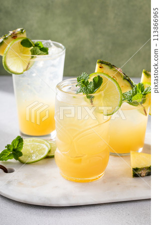 Variety of pineapple and lime cocktails or mocktails, mai tai, refreshing drinks idea Variety of pineapple and lime cocktails or mocktails, mai tai, refreshing drinks idea 113866965