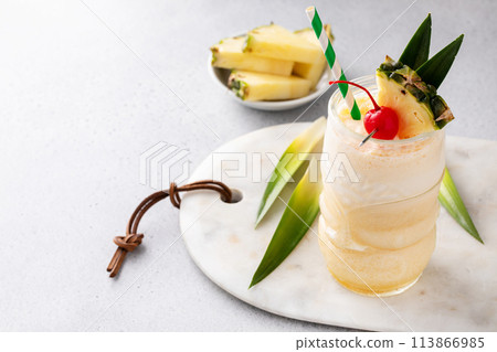 Tropical tiki cocktail pina colada in a fun glass garnished with pineapple Tropical tiki cocktail pina colada in a fun glass garnished with pineapple 113866985