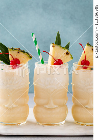 Pina colada in a tiki glass, tropical tiki cocktail with coconut and pineapple Pina colada in a tiki glass, tropical tiki cocktail with coconut and pineapple 113866988