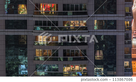 Night view of exterior apartment building timelapse. High rise skyscraper with blinking lights in windows 113867086