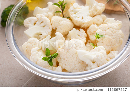Raw cauliflower florets in a glass bowl, ready to roast with spices and olive oil Raw cauliflower florets in a glass bowl, ready to roast with spices and olive oil 113867217