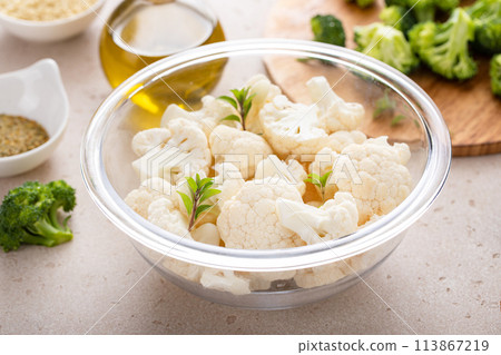 Raw cauliflower florets in a glass bowl, ready to roast with spices and olive oil Raw cauliflower florets in a glass bowl, ready to roast with spices and olive oil 113867219