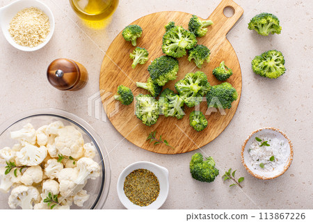 Cooking with broccoli and cauliflower, getting ready to roast vegetables with spices and olive oil Cooking with broccoli and cauliflower, getting ready to roast vegetables with spices and olive oil 113867226