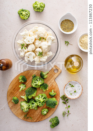 Cooking with broccoli and cauliflower, getting ready to roast vegetables with spices and olive oil Cooking with broccoli and cauliflower, getting ready to roast vegetables with spices and olive oil 113867230