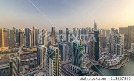 Aerial top view of Dubai Marina morning timelapse. Modern towers and traffic on the road 113867385