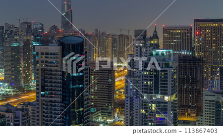 Aerial top view of Dubai Marina night to day timelapse. Modern towers and traffic on the road 113867403