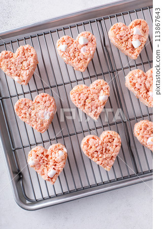 Pink heart shaped rice krispie treats on a cooling rack Pink heart shaped rice krispie treats on a cooling rack 113867643