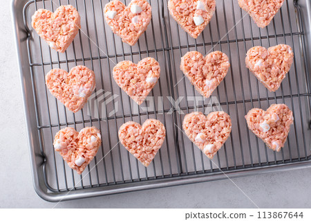 Pink heart shaped rice krispie treats on a cooling rack Pink heart shaped rice krispie treats on a cooling rack 113867644