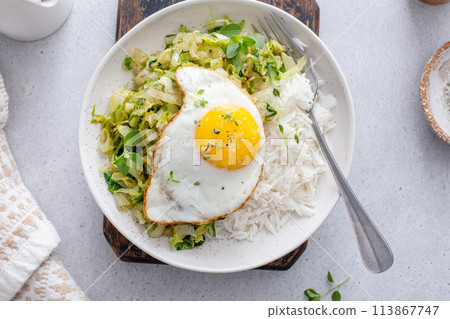 Sauteed green cabbage or lettuce with fried egg, healthy breakfast idea Sauteed green cabbage or lettuce with fried egg, healthy breakfast idea 113867747
