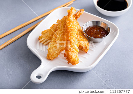Cooked tempura shrimp on a plate with dipping sauce 113867777